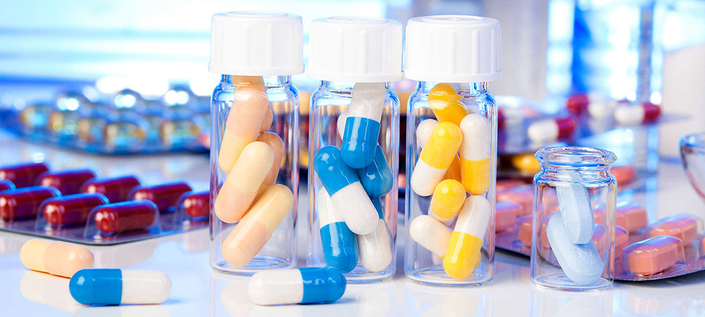 کپسول های خوراکی و مواد اولیه دارویی رنگی در ظروف در دار شیشه ای آزمایشگاهی