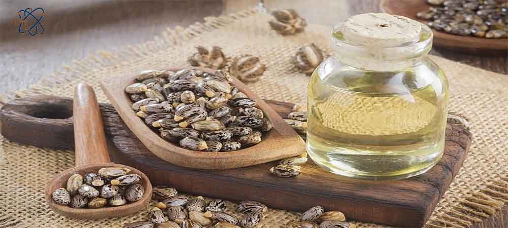 روغن کرچک در داخل شیشه همراه با دانه های گیاه کرچک