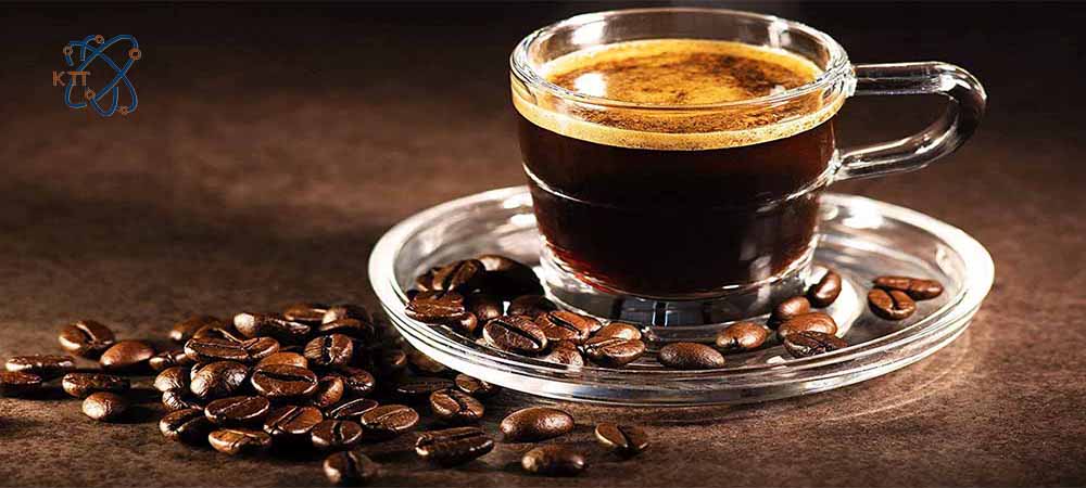 یک فنجان قهوه در کنار دانه های قهوه
