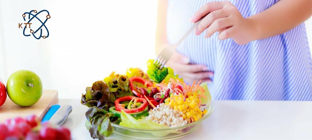 یک خانم باردار در حال استفاده از سبزیجات کلم بروکلی، فلفل قرمز، ذرت و کاهو که حاوی اسید فولیک هستند