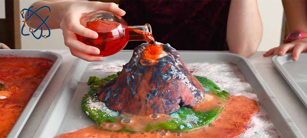 ریختن مایع قرمز رنگ بر روی ماکت رنگی برای آتشفشان خانگی