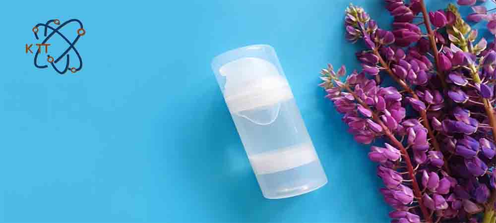 یک قوطی ژل روان کننده بی رنگ در کنار گلهای کوچک بنفش رنگ